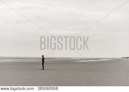 LIVERPOOL, UK - FEB 23, 2020: Antony Gormley's Another Place artwork on beach in England in United Kingdom