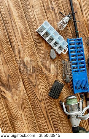 Flat Lay With Fishing Tackle, Fishing Rod And Plastic Box With Fishing Tackle And Hooks, Feeders On 