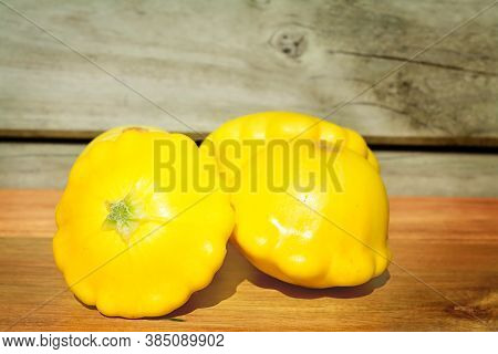 Group Of Bright Yellow Patty Pans On A Wooden Chopping Board. Selective Focus