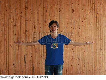 Man Wearing New York Flag Shirt And Standing With Arms Wide Open On The Wooden Wall Background, Coat