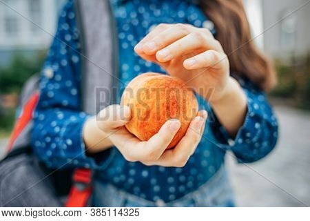 Healthy School Breakfast, Peach In The Hands Of A Schoolgirl.