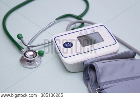 Stethophonendoscope And Blood Pressure Meter On A Green Background.concept Of Medical Services And I