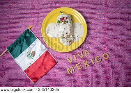 Typical Mexican Dish, Chiles En Nogada On A Yellow Plate, A Little Mexican Flag And Viva Mexico, Phr