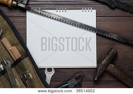 Strumenti per la costruzione e Notepad vuoto sullo sfondo in legno