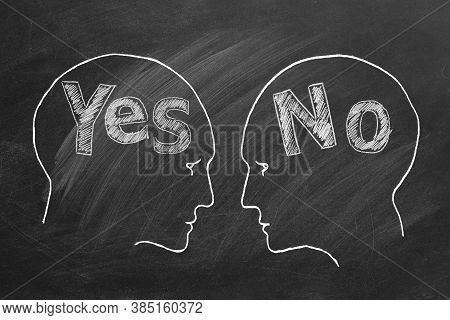 Chalk Illustration On Blackboard. Two Male Heads Face To Face With Yes And No On The Inside. Conflic