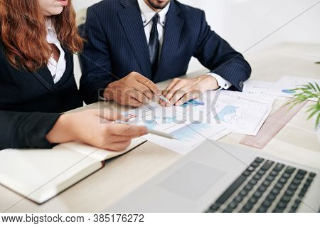 Cropped Image Of Financial Analysts Discussing Charts And Reports At Meeting When Working On Stategy