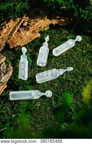 Five Beauty Face, Hair, Medical Ampoule Sample Containers Cosmetic On Grass. Top View. Dermatology C