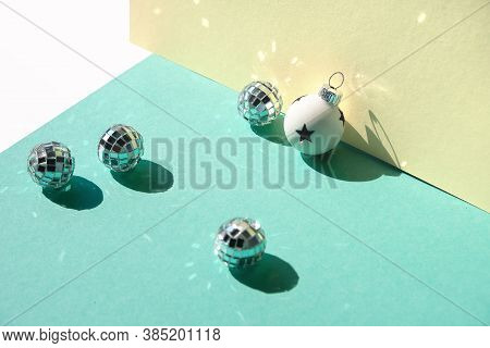 Mirror Balls And Silver Xmas Baubles On Mint Green And Yellow Layered Paper. Geometric Christmas Bac