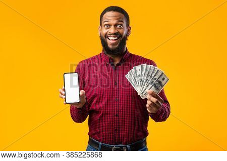 Black Surprised Man Holding Mobile Phone With Blank Empty Screen And Fan Of Cash Money In Dollar Ban