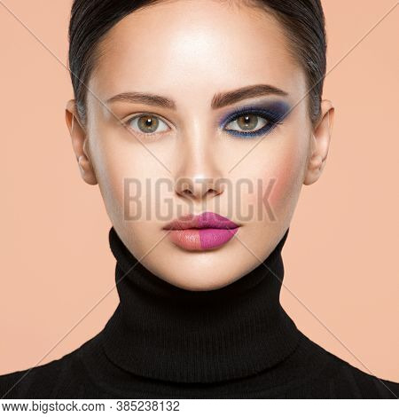 One half face of a beautiful white woman with  bright makeup and the other is natural. Woman portrait with a deep blue eye makeup of one eye. Natural and  vivid make-up on a female face. Fashion style