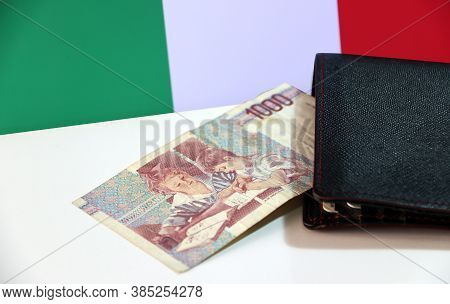 One Thousand Lire Of Italy Banknote With Black Wallet On The White Floor With Italia Flag Background