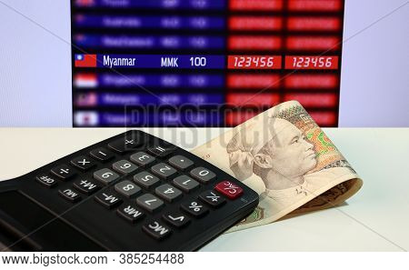 Seventy Five Of Banknote Currency Myanmar Kyats With Calculator On The White Floor With Digital Boar