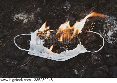Burning A Medical Mask, Surgical Mask With Cleansing Decontaminate Fire. Concept Of End Of Coronavir