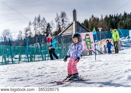 Young happy skier girl learning how to ski on the green ski zone. Young skier having fun on ski slope, Bialka Tatrzanska, Tatry, Poland