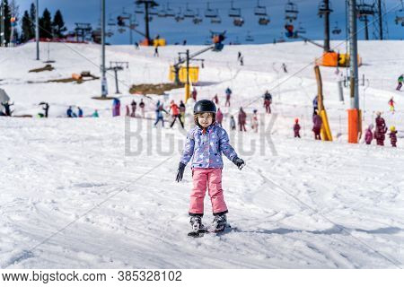 Young happy skier girl learning how to ski on the green ski zone. Young skier having fun on ski slope, Bialka Tatrzanska, Tatry, Poland