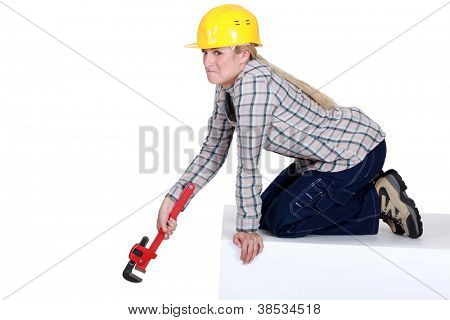 Infeliz tradeswoman segurando uma chave de tubulação