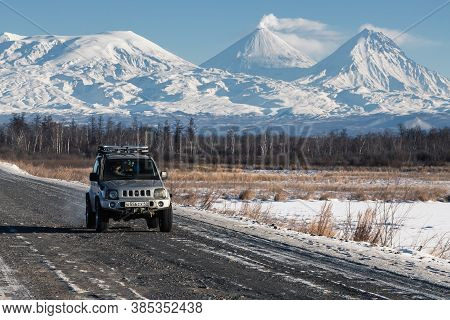 Japanese Sport Utility Vehicle Suzuki Jimny Driving Along Road On Background Beautiful Winter Landsc