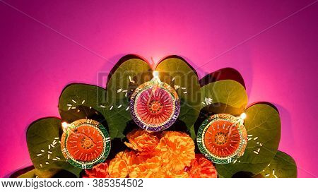 Happy Dussehra. Clay Diya Lamps Lit During Dussehra With Yellow Flowers, Green Leaf And Rice. Dusseh
