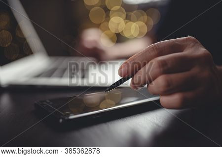 Close Up Shot Of Hands Using Smart Pen Typing On Smart Phone For Searching With Laptop On Glow Bokeh