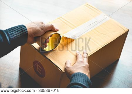 Close Up Male Hand Wrapping Packaging Box By Tape.business Online Shopping.logistic Transportation S
