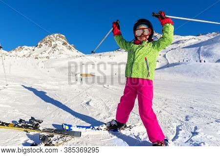 Active Adorable Preschooler Caucasian Kid Girl Portrait With Ski In Helmet, Goggles And Bright Suit 