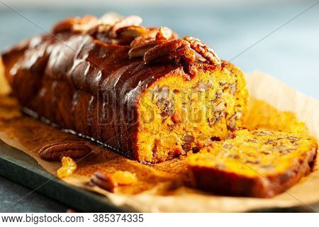 Delicious pumpkin pecan and raisin cake on cutting board. Loaf of pumpkin bread.