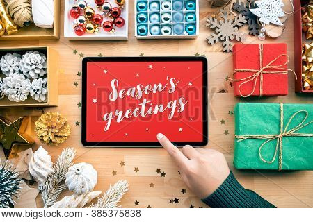 Season's Greetings With Merry Christmas Concepts With Young Female Using Tablet And Ornament Element