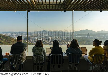 Seoul, South Koera - Oct 30, 2019: People In A Cafe Overlooking Seoul City At Sunset