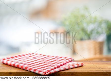 Red Fabric,cloth On Wood Table Top On Blur Kitchen Counter (room)background.for Montage Product Disp