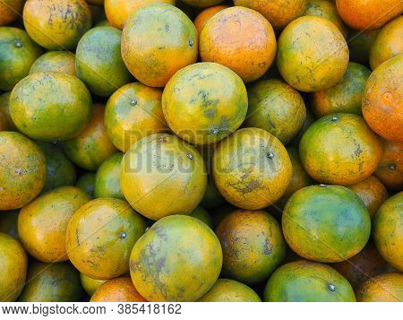 Pile Of Tangerines For Sale In The Market. Full Frame Photo. Concept Of Fruits Healthy