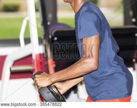 A Cross Country Runner Is Holding A Twenty Five Pound Weight Twisting Side To Side In A Weightroom D
