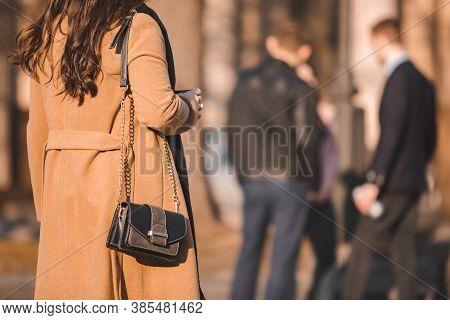 Rear View Of Woman In Brown Topcoat Walking By Street