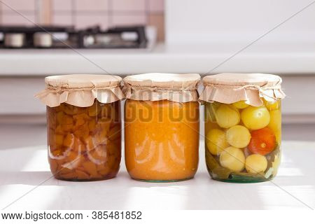 Glass Jurs Of Various Preserved, Canned Foon In The Kitchen In Sunny Day.