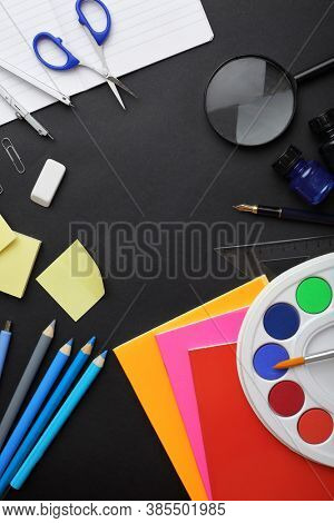 school supplies on black chalkboard background. back to school