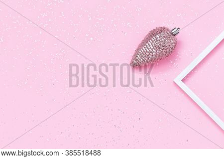 Merry Christmas And Happy New Year Background With Bump Christmas Toy On Shiny Pink Paper. Flat Lay.