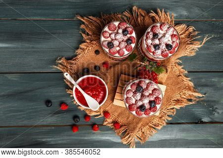 Healthy Raspberry Fruit Dessert With Skyr Yogurt, Granola Layered In Jar Surrounded By Ingredients, 