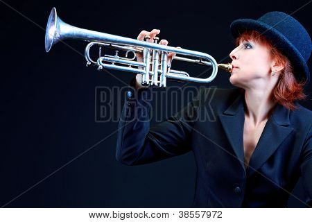Retrato de um músico tocando a trombeta. Fundo preto.