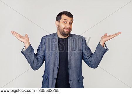 A Young Businessman Man With A Beard In A Jacket, Shrugs His Shoulders, Arms Outstretched Complete D