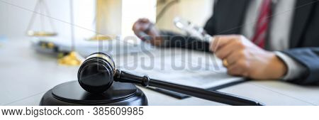 Male Lawyer Or Judge Working With Contract Papers, Law Book And Wooden Gavel On Table In Courtroom, 
