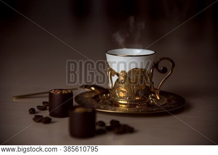 A Golden Coffee Cup, A Spoon, Chocolate And Coffee Beans On The Table, Luxurious Elegance Style Conc