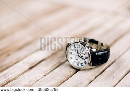 Men's Wrist Watch With Black Strap Lies On Wooden Surface. Selective Focus.