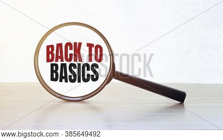 Magnifying Glass With Text Back To Basics On Wooden Table.