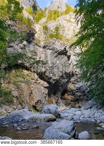 Cheile Rametului Gorges Wild Natural Park River Area. Waterfall On Small River In Dense Forest In Al