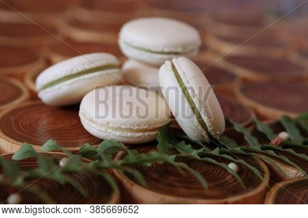 White Delicate Lowly Macaroons On A Wooden Background. The Pastel Tone Of The Cream Inside The Frenc