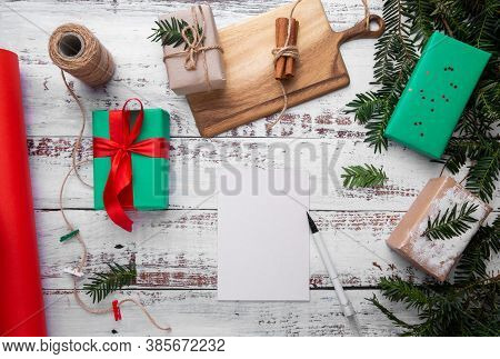 Postcard And Pen Lie On A Wooden Table Next To Gifts