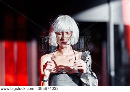 Blonde On A Red Background With Stylish Clothes.