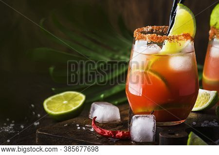Michelada - Mexican Alcoholic Cocktail With Beer, Lime Juice, Tomato Juice, Spicy Sauce And Spices, 