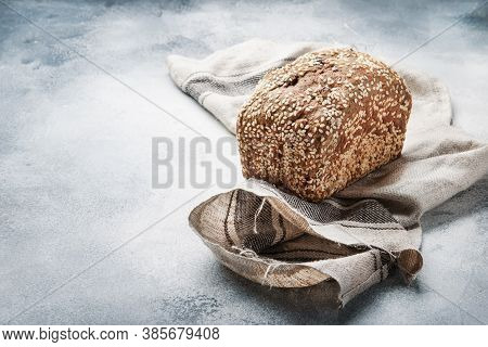 Whole Wheat Organic Rye Dark Bread With Pumpkin Seeds, Dried Fruit, Raisins And Sesame Seeds On Gray