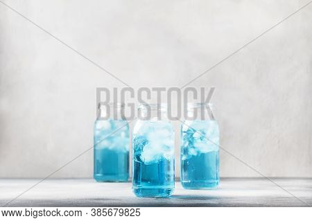 Summer Refreshing Cold Drink, Isotonic Blue Water In Bottles, Gray Table Background, Selective Focus