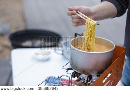 Uljin,south Korea-november 2019: Hand Pulling A Korean Instant Noodle From A Stainless Steel Pot And